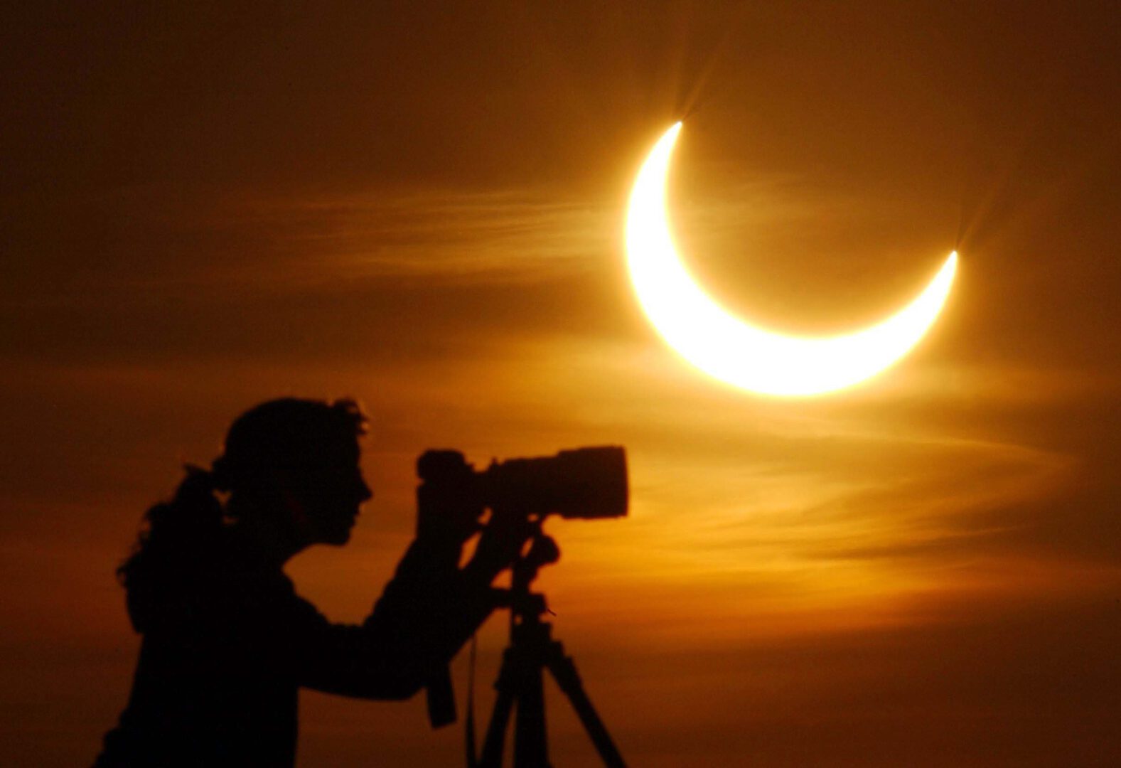 A photographer prepares to take a picture of a partial solar eclipse